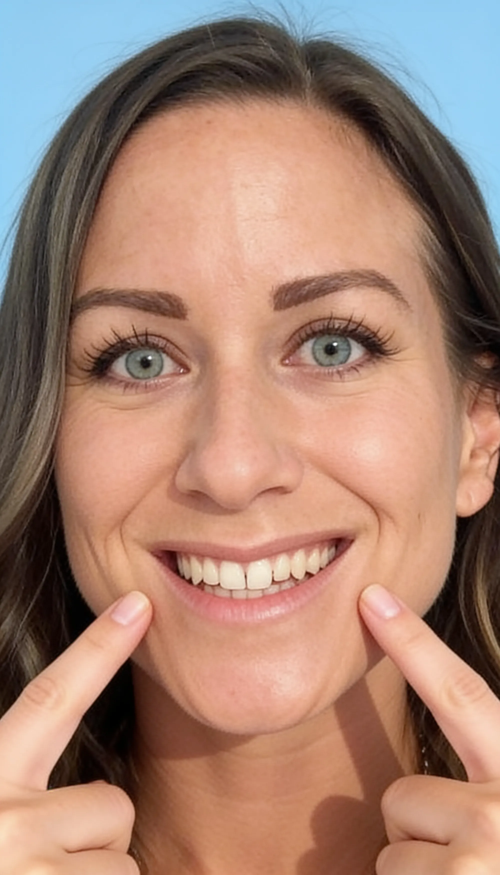 Smiling patient pointing at her healthy teeth after root canal treatment in Grande Prairie
